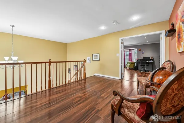 a view of a hallway with wooden floor and chairs