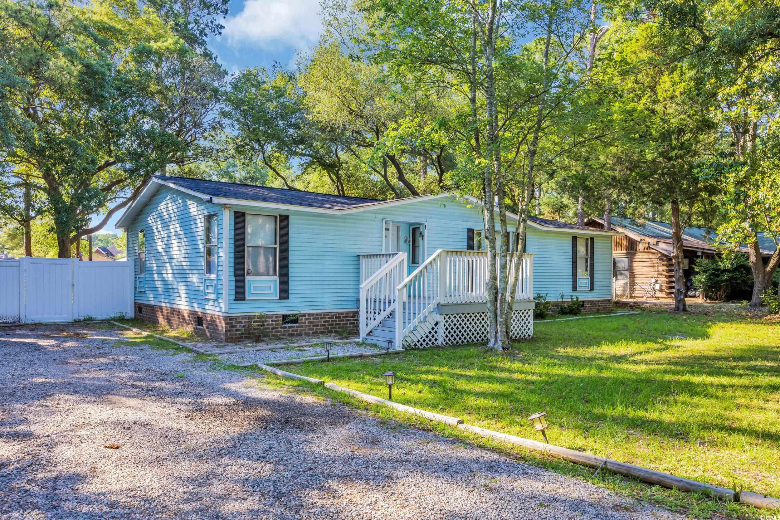 View of front of property featuring crawl space and a gate