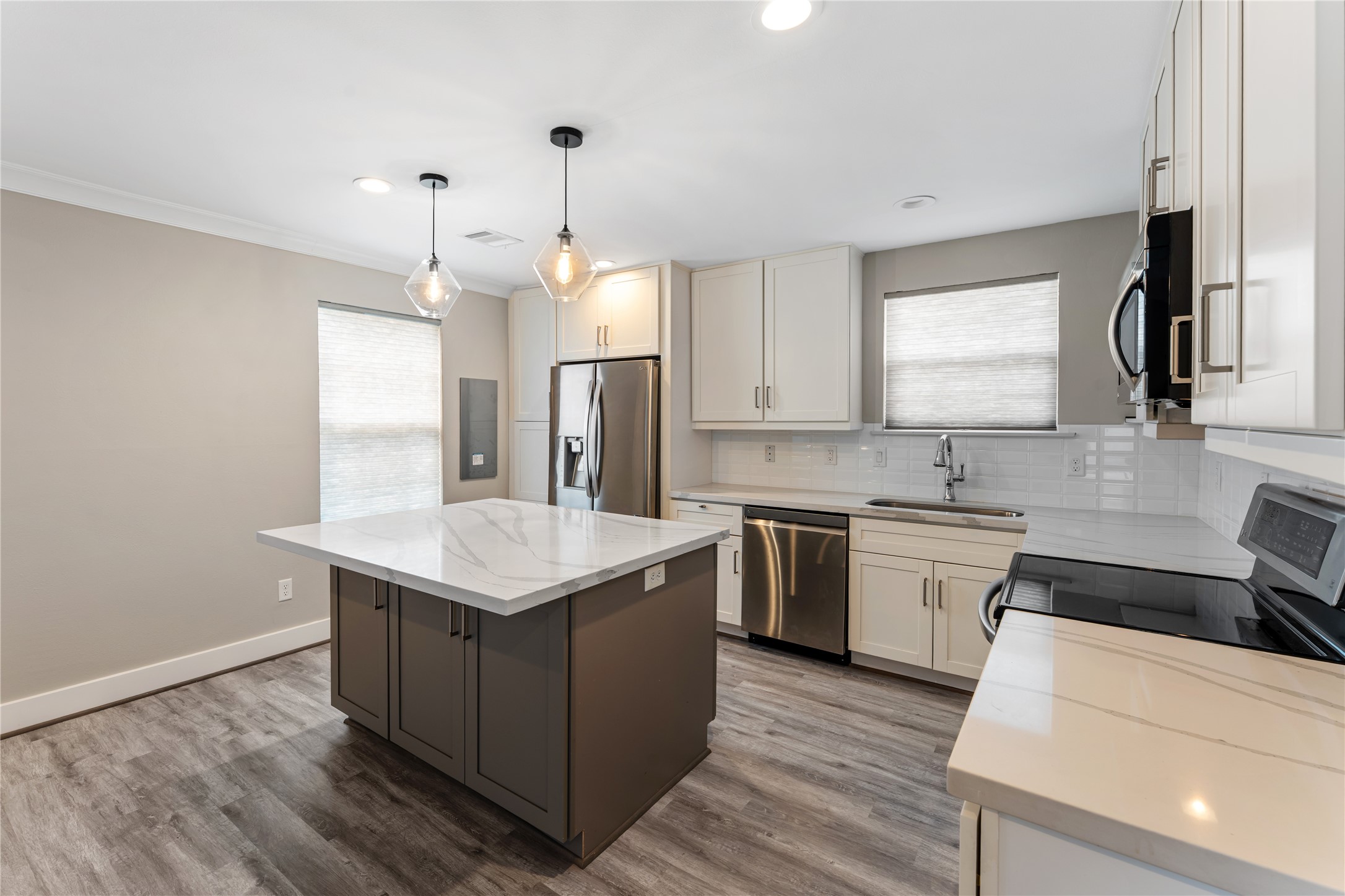 809 East 40th Street Houston, TX 77022 - Photo 8 of 27 This updated kitchen features stainless steel appliances, modern cabinetry, and a large Quartz island ideal for entertaining. Clean finishes and thoughtful design make this space both functional and stylish.