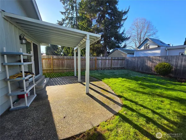 a view of a backyard with a backyard and wooden fence