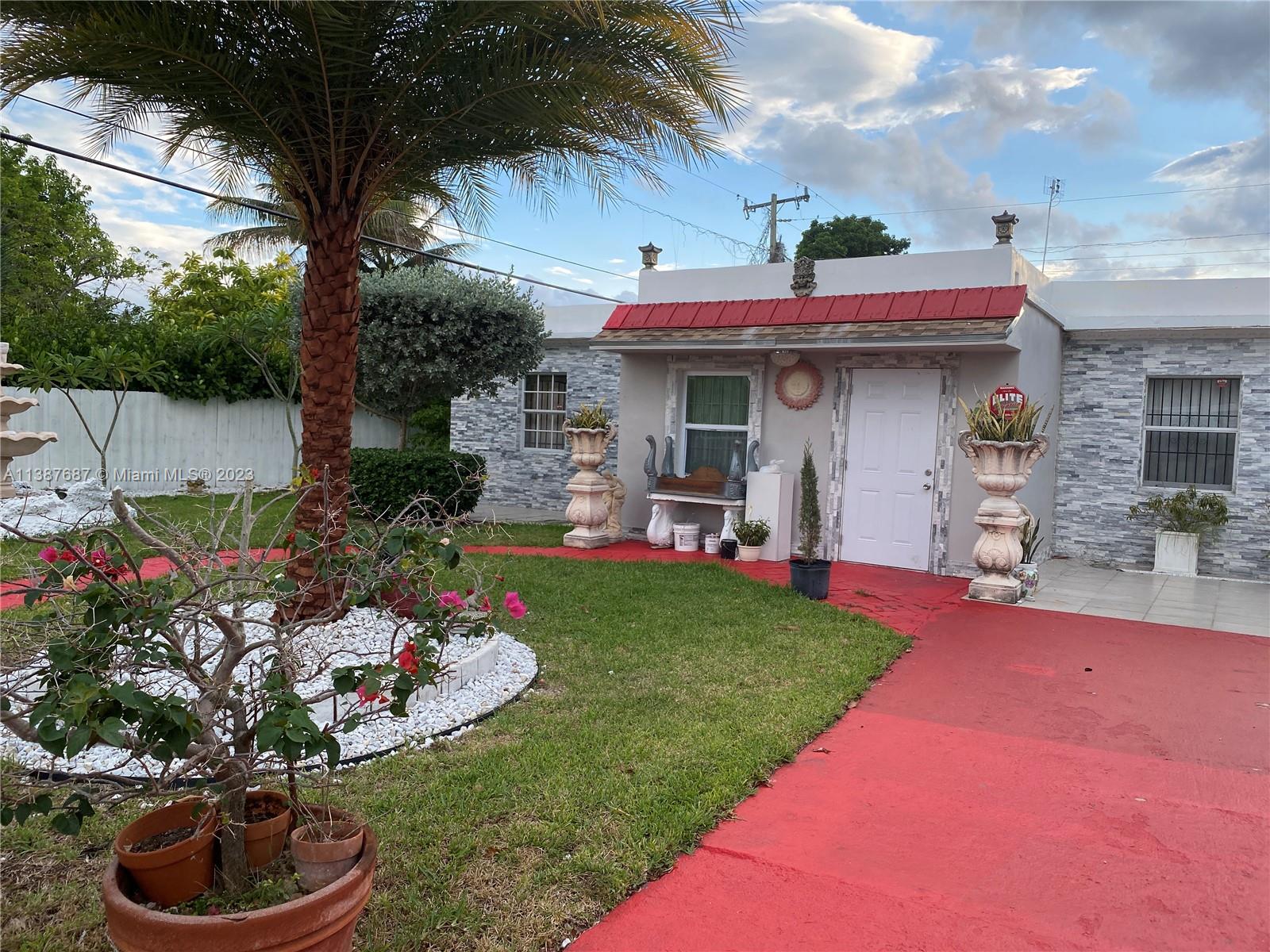 29220 Kansas Road Homestead, FL 33033 - Photo 4 of 16 a front view of a house with a garden and plants