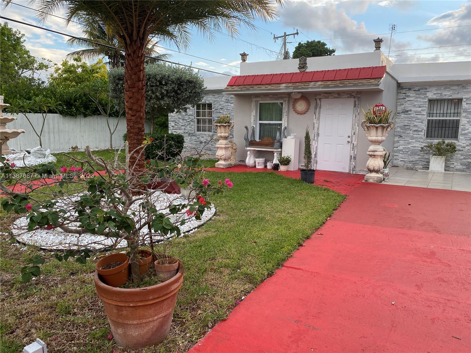29220 Kansas Road Homestead, FL 33033 - Photo 5 of 16 a view of a backyard with potted plants and a fountain