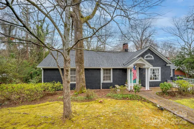 a front view of house with yard and trees around