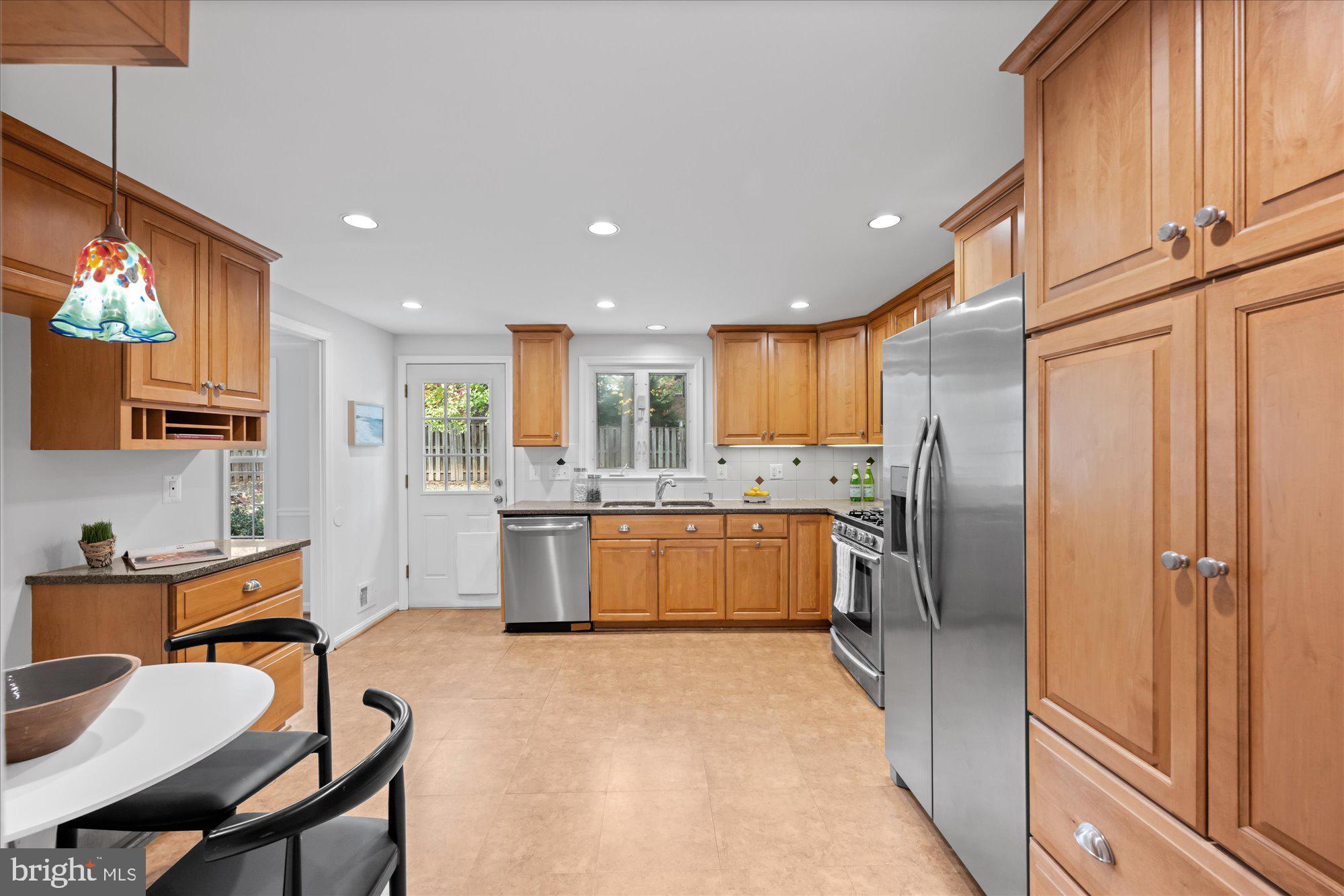8311 Aqueduct Road Potomac, MD 20854 - Photo 6 of 27 a kitchen with stainless steel appliances granite countertop a refrigerator and a stove top oven