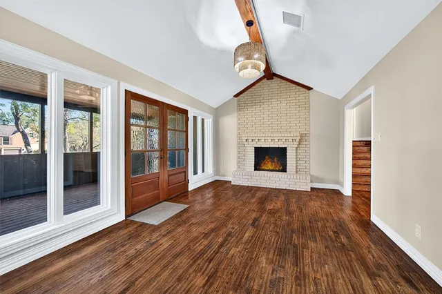 a view of empty room with wooden floor and fireplace