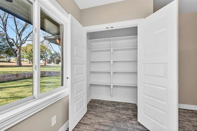a view of empty room with wooden floor and fireplace