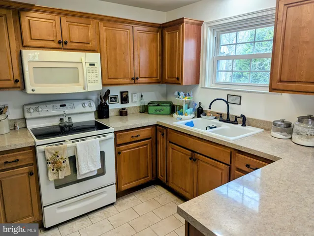 a kitchen with stainless steel appliances granite countertop a sink a stove and cabinets