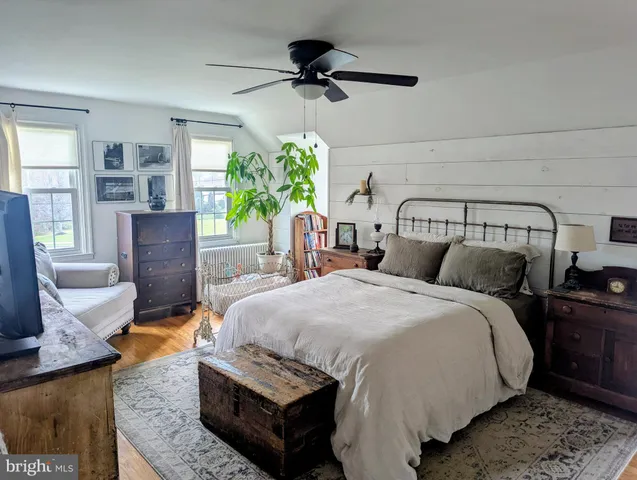 a bedroom with a bed and a flat tv screen on dresser