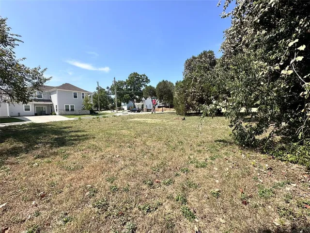 a backyard of a house with table and chairs under an umbrella