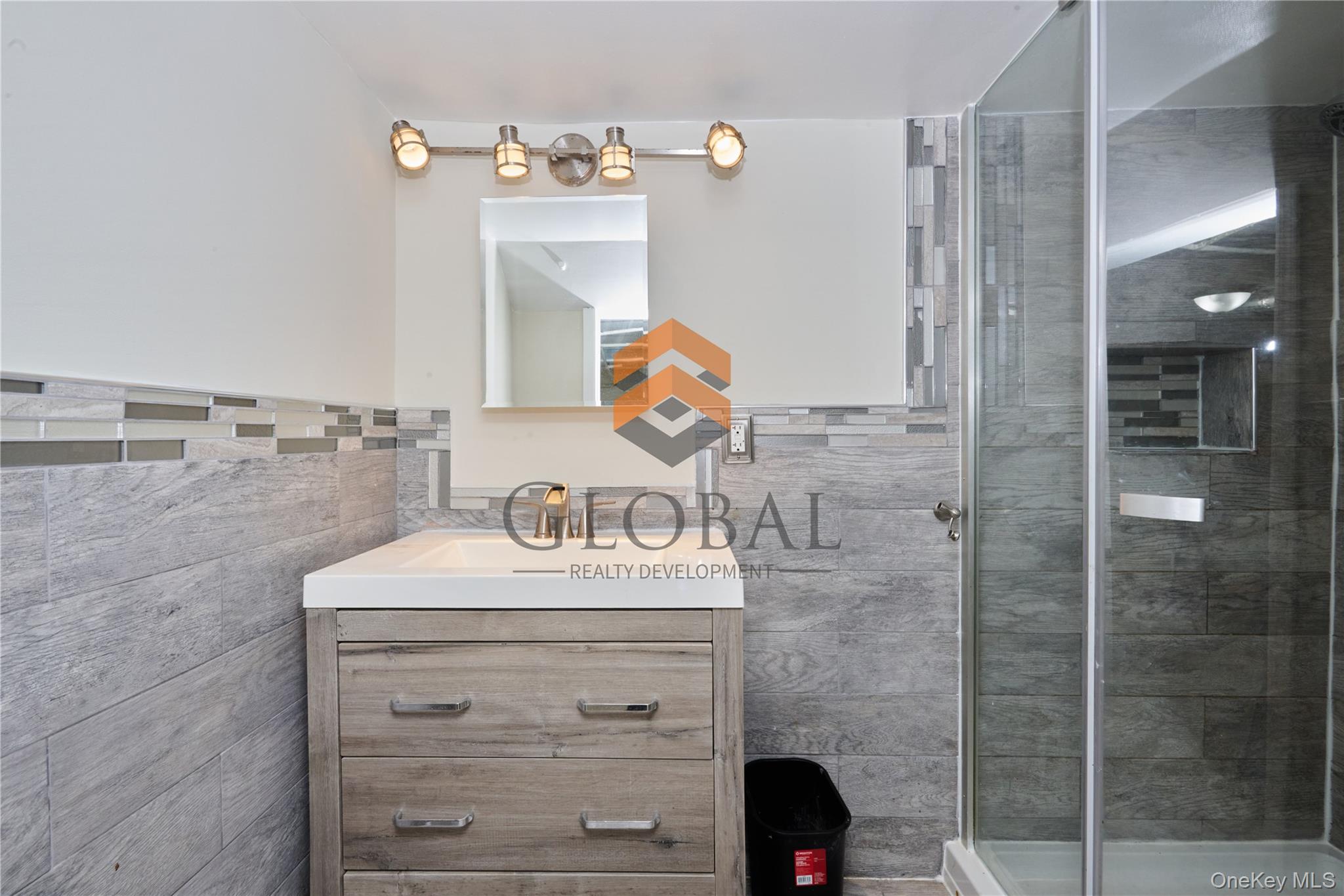 680 Union Avenue Bronx, NY 10455 - Photo 8 of 15 Bathroom with vanity, tile walls, and a shower stall