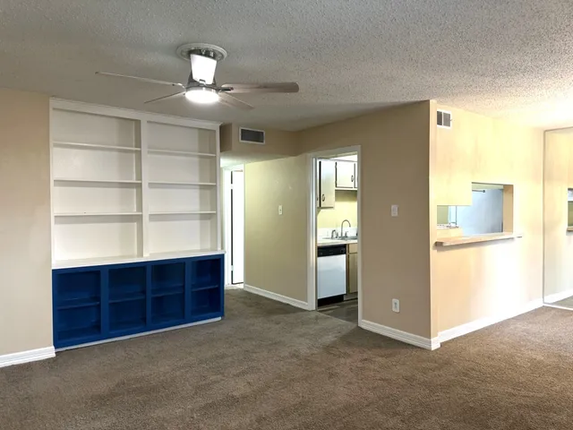 an empty room with shelves and a window