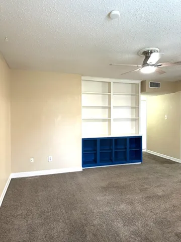 an empty room with closet and windows