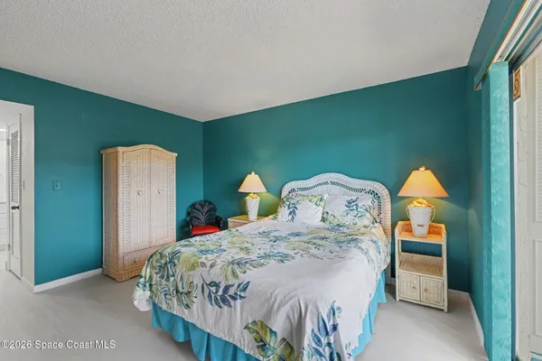 a bedroom with a bed next to a window