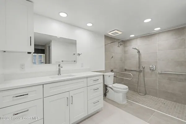 a bathroom with a double vanity sink toilet and shower