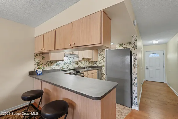 a kitchen with stainless steel appliances granite countertop a sink a refrigerator and a stove