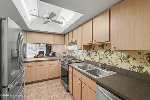 a kitchen with stainless steel appliances granite countertop a sink a stove and cabinets