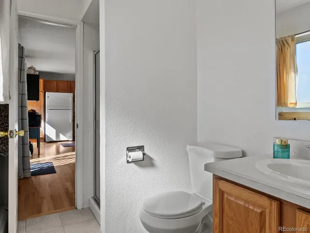 a bathroom with a granite countertop toilet sink and mirror
