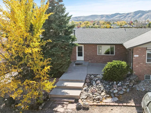 a front view of a house with a yard and mountain view