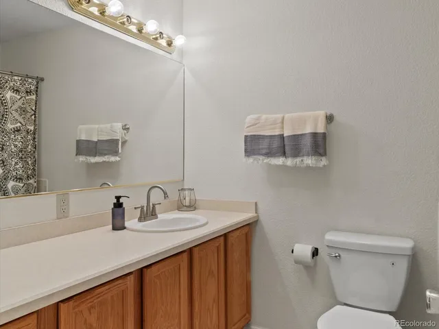 a bathroom with a sink mirror vanity and toilet