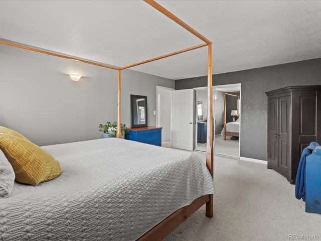 a bedroom with a bed closet and a mirror