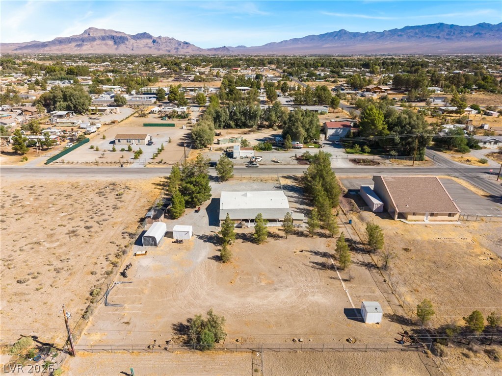 1551 West Wilson Road Pahrump, NV 89048 - Photo 58 of 68 Majestic mountain ridges frame a sprawling desert property under clear open skies.