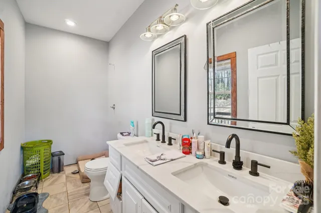 a bathroom with a granite countertop sink a toilet and mirror