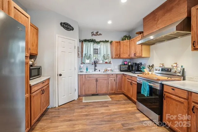 a kitchen with stainless steel appliances granite countertop a refrigerator and a stove top oven