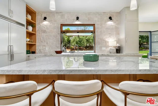 a kitchen with stainless steel appliances granite countertop a table and chairs in it