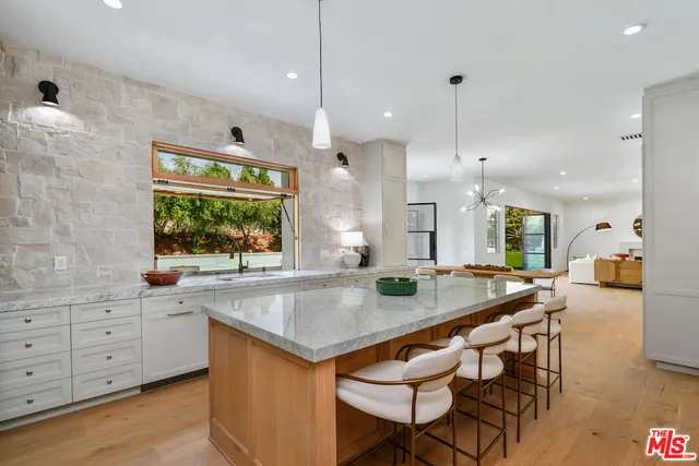 a kitchen with stainless steel appliances granite countertop a stove a sink and a wooden floors