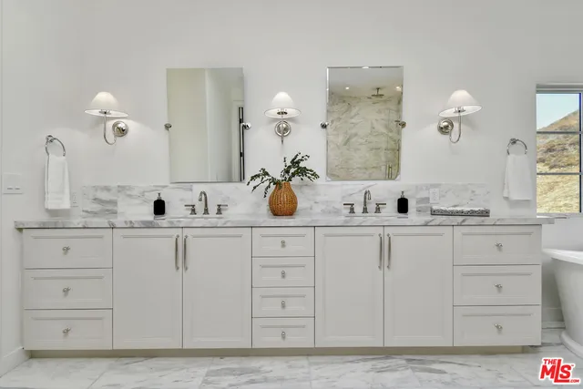 a bathroom with double sink and a mirror