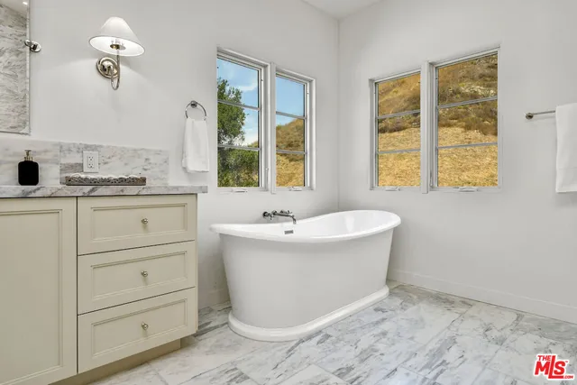a bathroom with a bathtub and next to a window