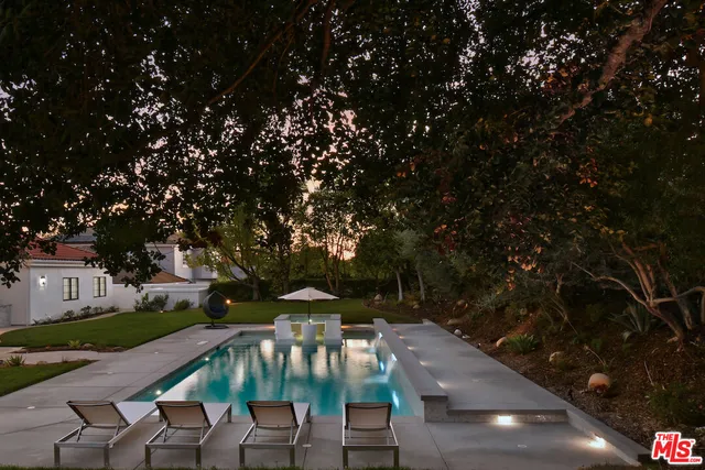 a view of a patio with table and chairs a barbeque with potted plants and large trees