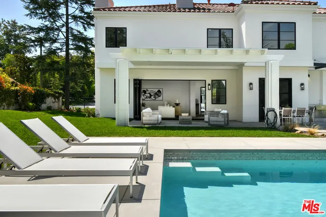 a view of a patio with table and chairs with plants and wooden fence