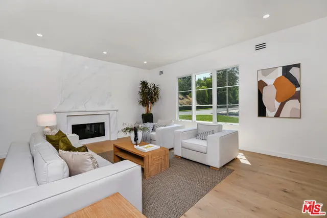 a living room with furniture a fireplace and a large window