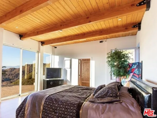 a bedroom with a bed and a flat screen tv