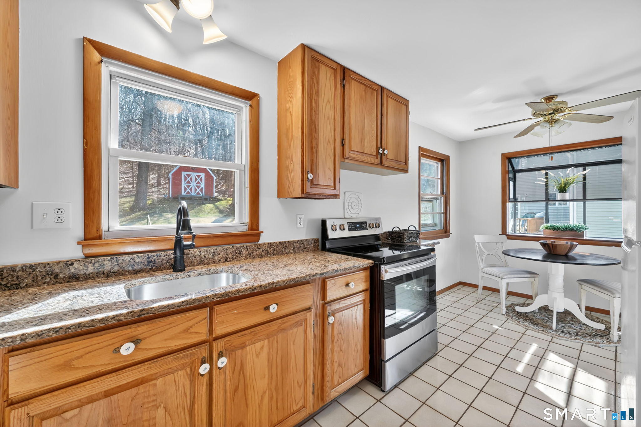 203 Brentwood Road Newington, CT 06111 - Photo 9 of 39 Kitchen has granite countertops and tile floor. Looking toward eating area and greenhouse window.