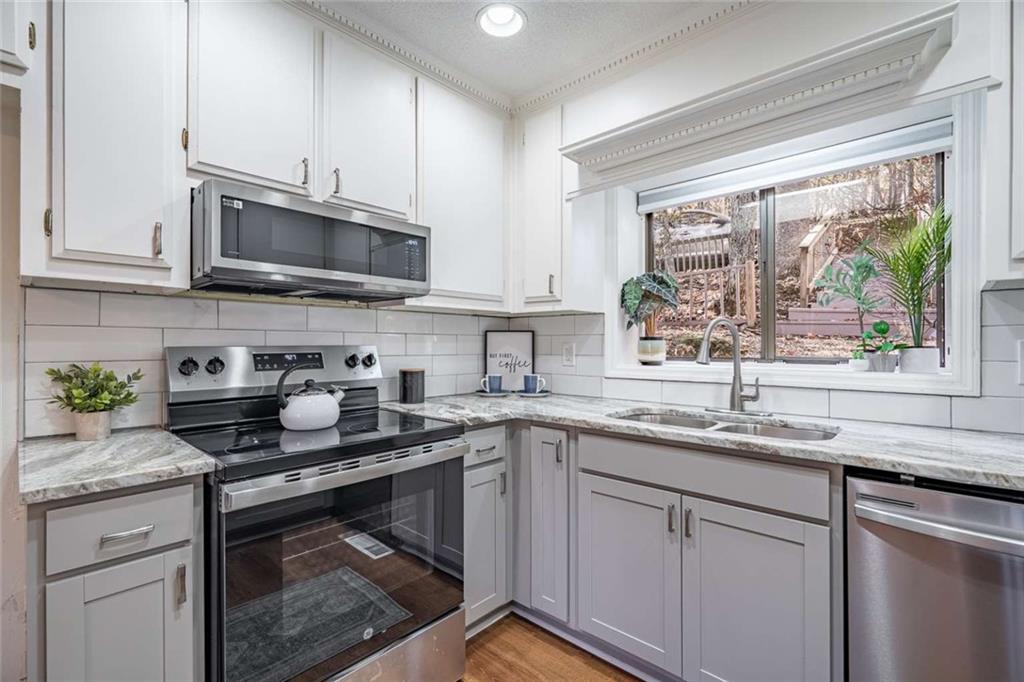 200 Villa Road, Unit 126 Jasper, GA 30143 - Photo 22 of 38 a kitchen with stainless steel appliances granite countertop a sink a stove a microwave and cabinets