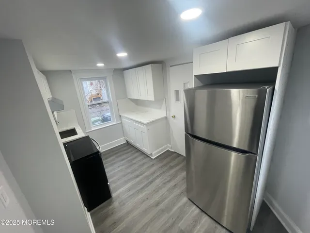 a kitchen with a refrigerator sink and cabinets