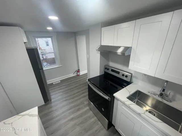 a kitchen with granite countertop a stove and a refrigerator