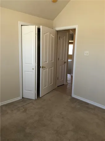 an empty room with closet and a bathroom