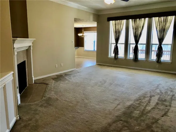 a view of an empty room with a fireplace and a window