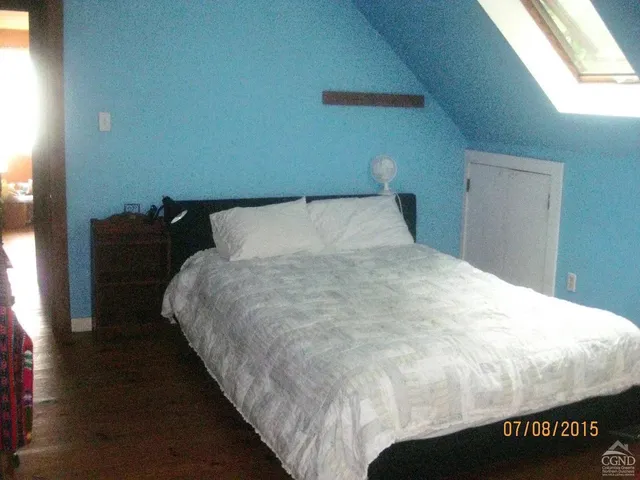 a large bed sitting in a bedroom next to a window