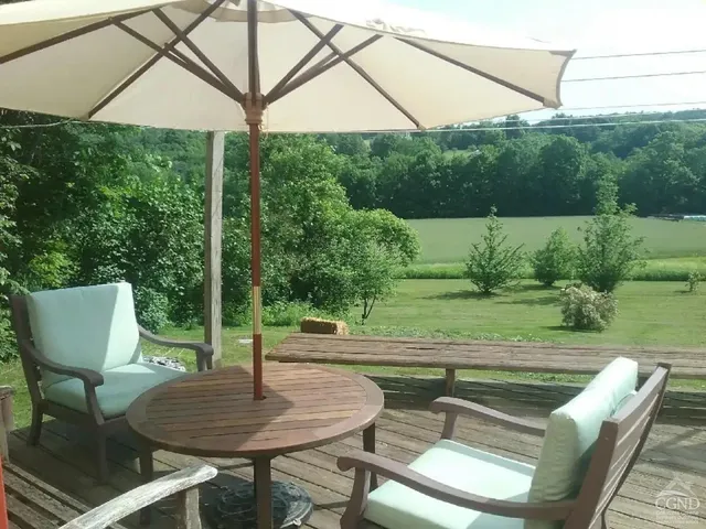 a view of a patio with a table chairs and a backyard