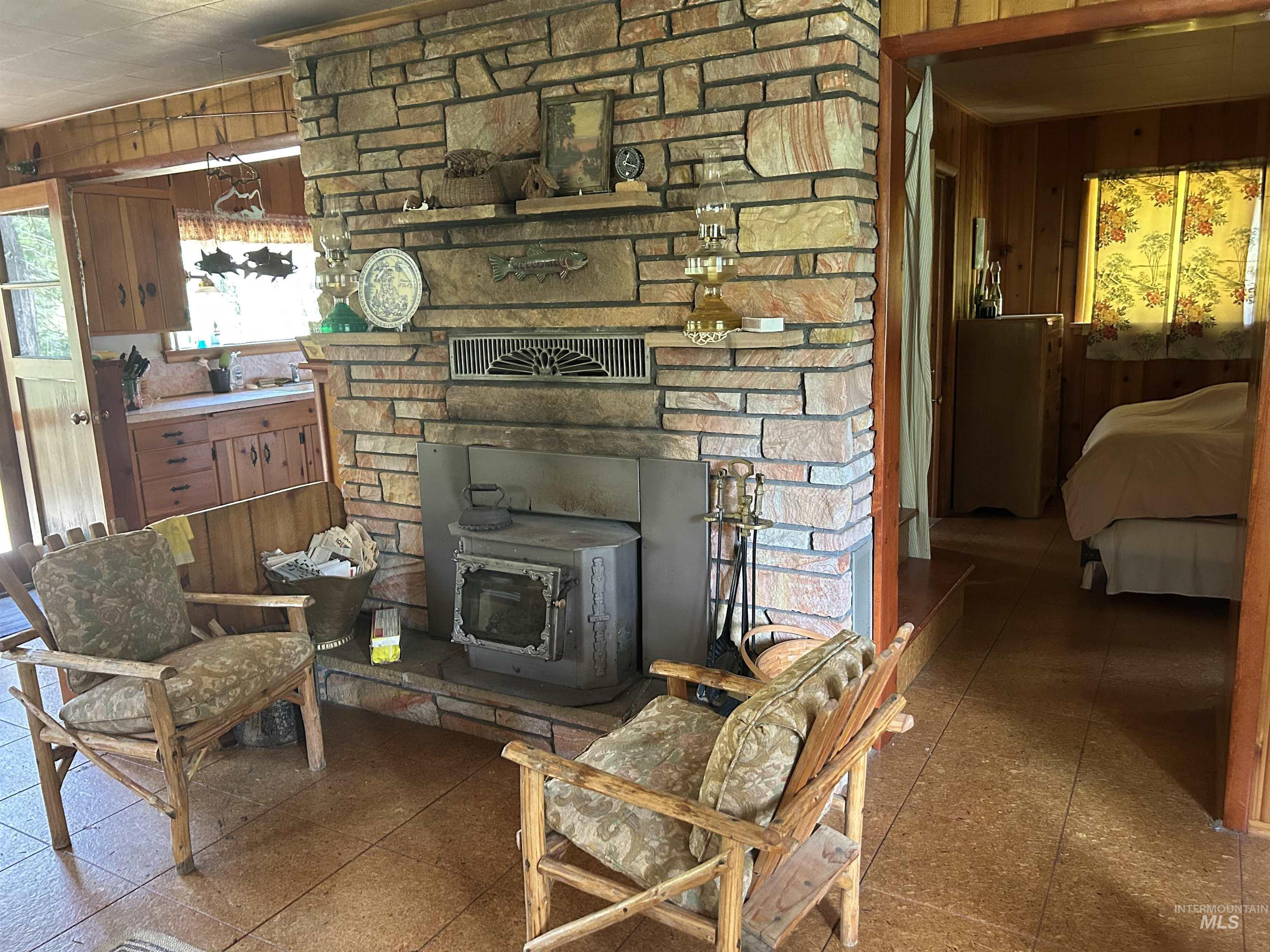 44 Long Creek Road Lowman, ID 83637 - Photo 11 of 42 Kitchen featuring extensive knotty pine paneling, wood-finish cabinetry, and a large double basin sink