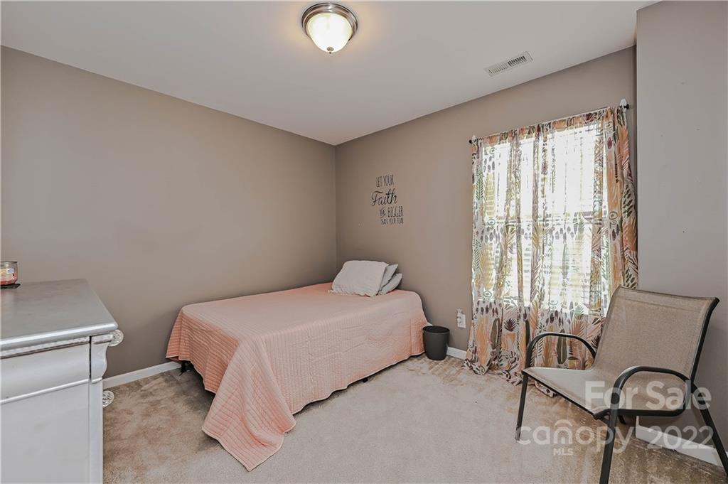 10311 Atkins Ridge Drive Charlotte, NC 28213 - Photo 14 of 18 a bedroom with a bed and a table in it