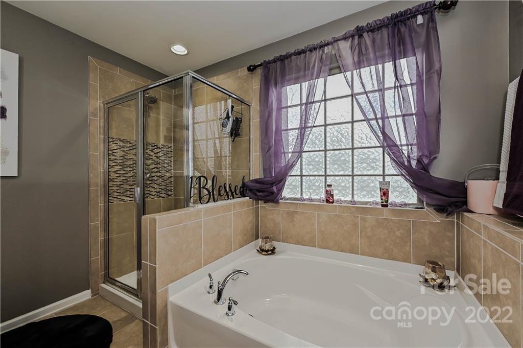 10311 Atkins Ridge Drive Charlotte, NC 28213 - Photo 15 of 18 a bathroom with a bathtub and next to a window