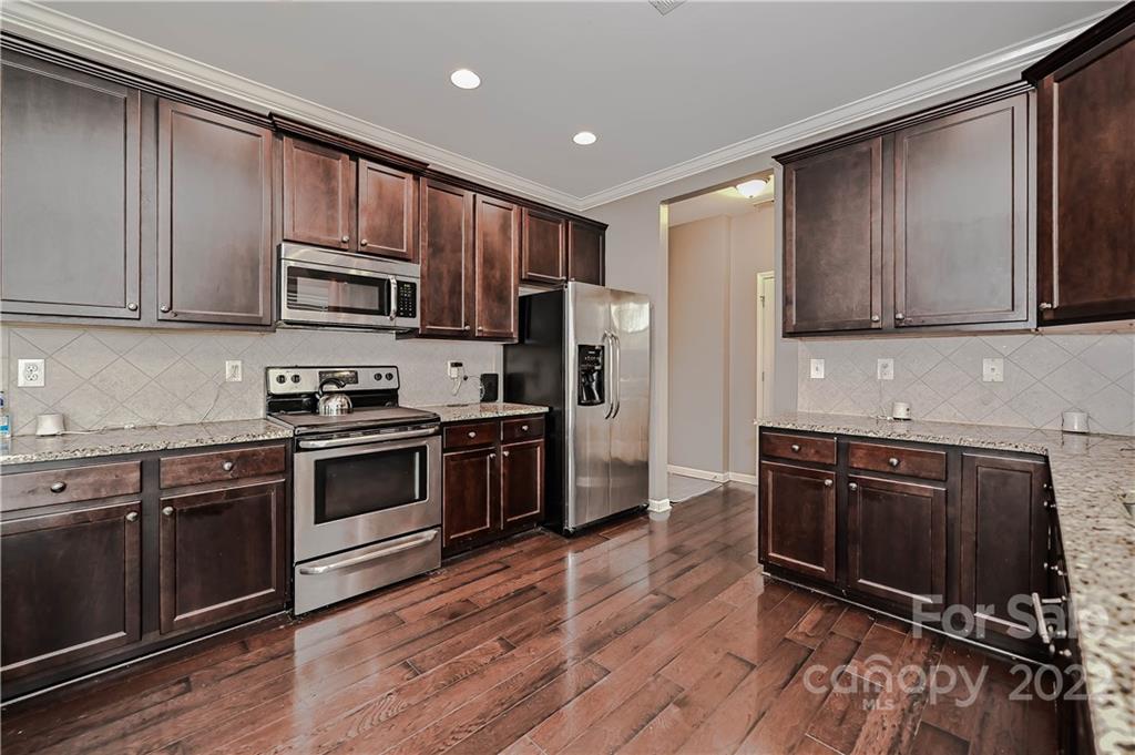 10311 Atkins Ridge Drive Charlotte, NC 28213 - Photo 4 of 18 a kitchen with stainless steel appliances granite countertop a stove a sink and a microwave