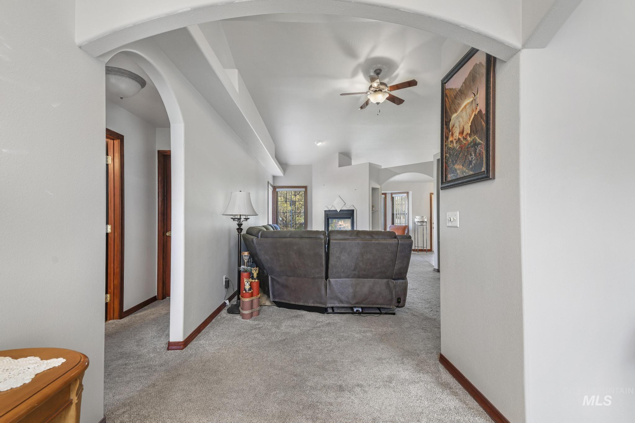 1558 Brookside Loop Twin Falls, ID 83301 - Photo 2 of 47 Archway entrance leading into a carpeted interior space with a ceiling fan and a fireplace visible in the background