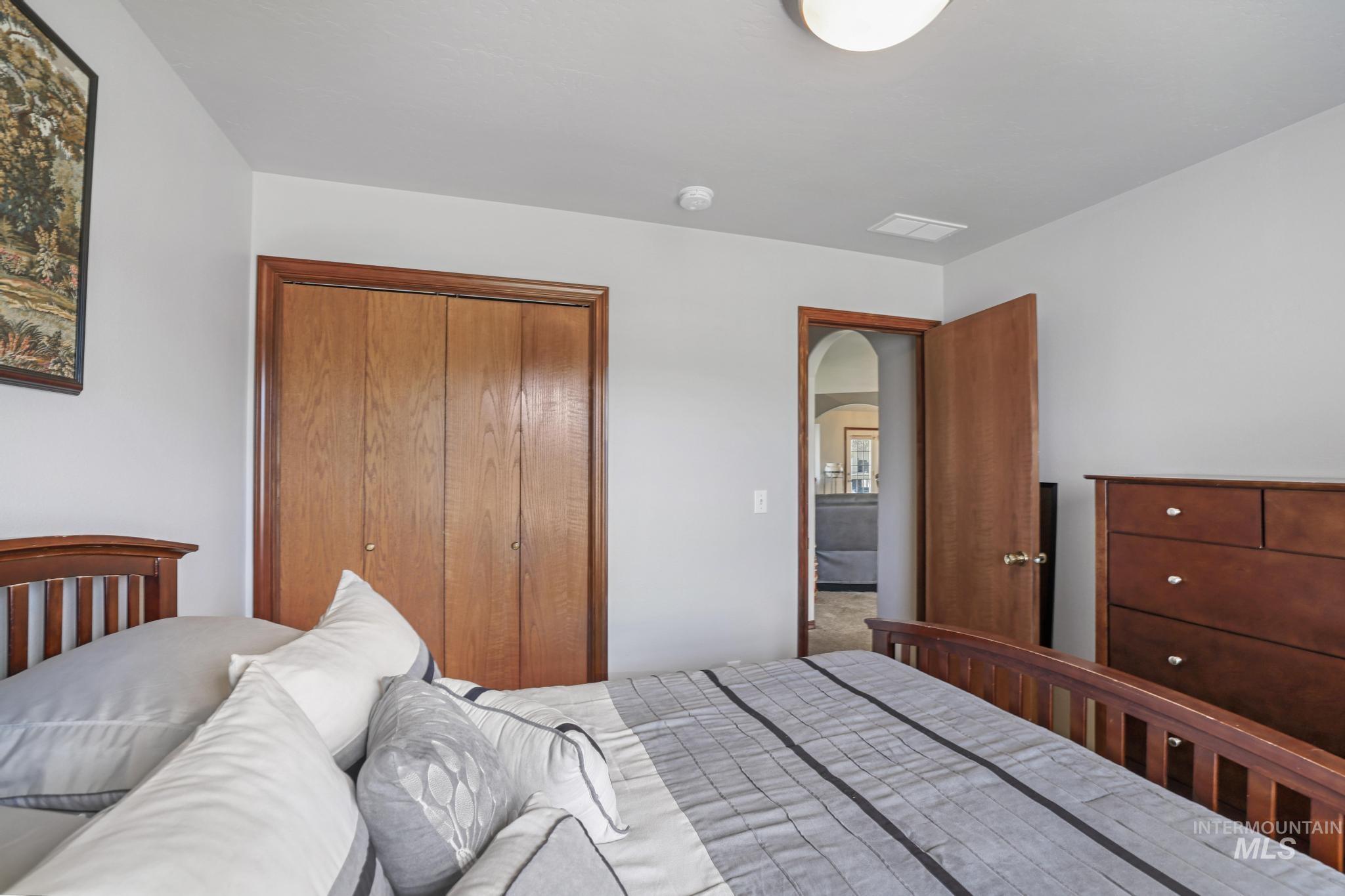 1558 Brookside Loop Twin Falls, ID 83301 - Photo 24 of 47 Bedroom featuring light gray walls, wood-finish closet doors, recessed lighting, and a wood-finish door frame with an arched interior doorway