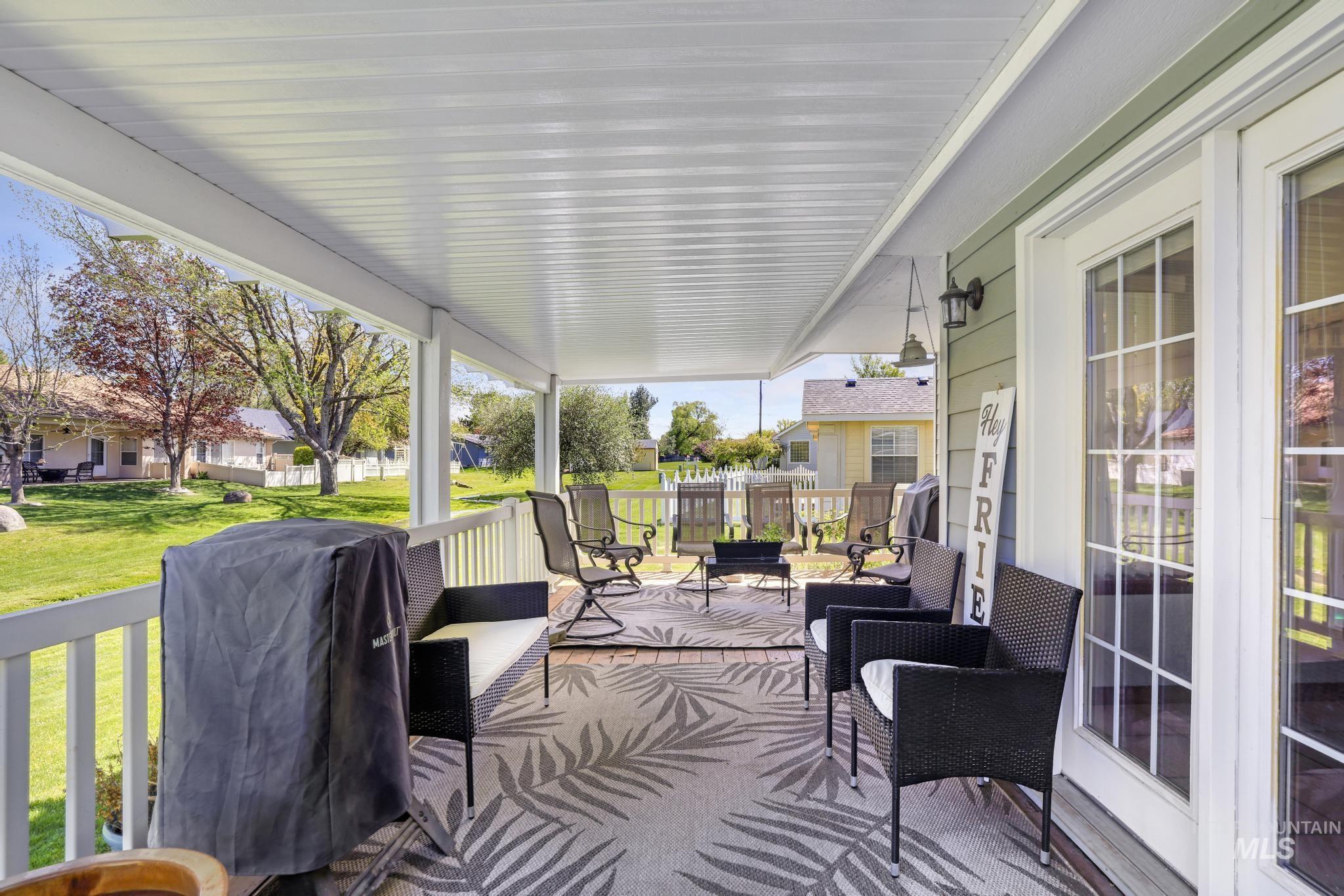 1558 Brookside Loop Twin Falls, ID 83301 - Photo 31 of 47 Covered outdoor patio featuring a white slatted ceiling, light green siding, white French doors, white railing, and a patterned area rug